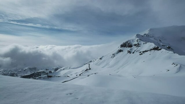 Grossgloknershtrasse in snow and clouds. Great high mountain road near Grossglokner mount in Austrian Alps, 4k