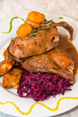 Roasted chicken in mushroom sauce with red onion and fried banana on decorated plate on restaurant table