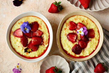 Creamy millet porridge with baked strawberries in to the bowl - 785683969