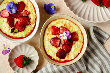 Creamy millet porridge with baked strawberries in to the bowl