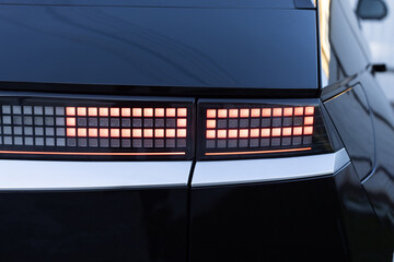 Car taillight. LED red taillight. Closeup tail light of a modern car. Rear light of a car. Rear lamp signals for turning car on street. Signal function to keep them distance. Trunk closeup