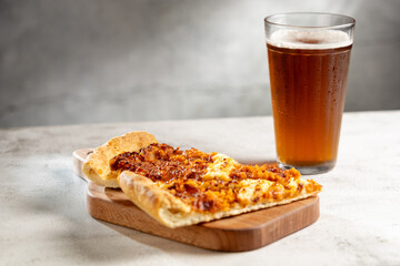 Slices of pizza with glass of beer on the table.