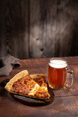 Slices of pizza with glass of beer on the table.