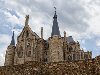 Vistas de la fachada del Palacio de Gaudí Astorga, con una muralla de de piedra y cúpulas en las...