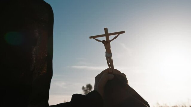 Monk raises crucifix to the sky