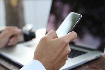 close up image of businessman working on his smartphone while sitting at the desk.