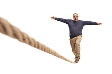 Full length portrait of a mature man walking on a rope isolated on white background