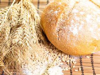 bread and wheat on wooden background