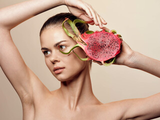 Woman holding watermelon slice in front of face without shirt on in summertime juicy refreshment...