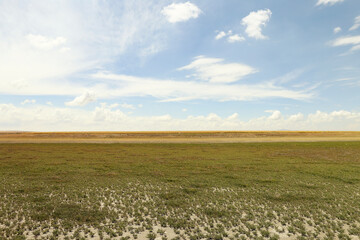 arid land with blue sky and white clouds