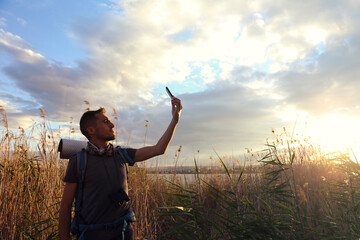 backpacker man taking selfie in nature. A man is taking a selfie with his cell phone in a nature