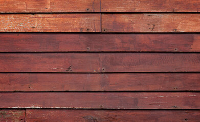Front view of an old, weathered and aged wooden wall painted in red. Abstract full frame textured...