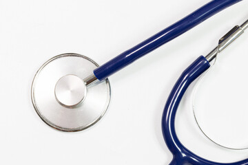 A blue stethoscope with a silver knob on the end. The stethoscope is laying on a white background