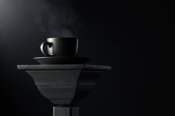 Black cup of coffee on a black background.