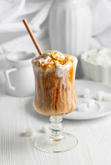 Iced caramel latte topped with whipped cream and caramel sauce. - 785702702