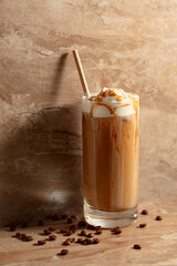 Iced caramel latte topped with whipped cream and caramel sauce. - 785702721