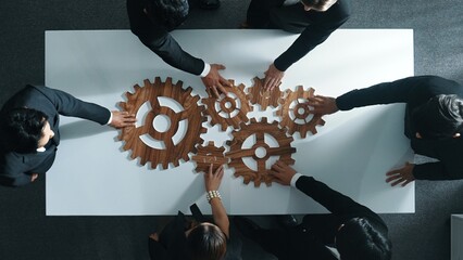 Top view of smart business people gather wooden cog together at meeting. Group of project manager helping and team working to solve problem at meeting room or workplace. Represent unity. Directorate.