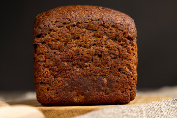 a square dark loaf of bread on the table