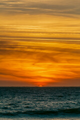picturesque sunset at seaside with an orange cloudy sky in details.	
