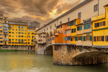 Ponte Vecchio bridge in Florence, Italy, with sunset sky. Medieval stone bridge with craft stores...