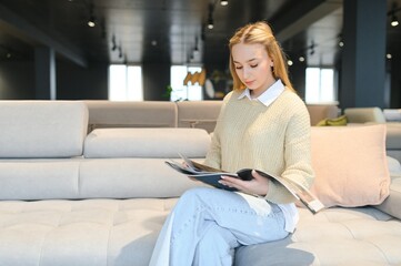 Woman designer at furniture store looking at textile swatch