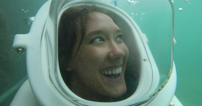 Cute woman with helmet deep under water