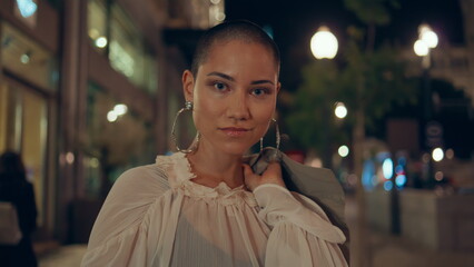 Shaved head girl posing at night urban street close up. Portrait beautiful woman