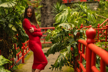 Template for a tourist travel postcard. Woman in the red dress in Monte Palace Tropical Gardens in Madeira, Funchal. Popular tourist botanical park at Madeira island, Portugal. - 785718935