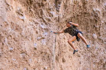 Climber descending a rock face using a rope