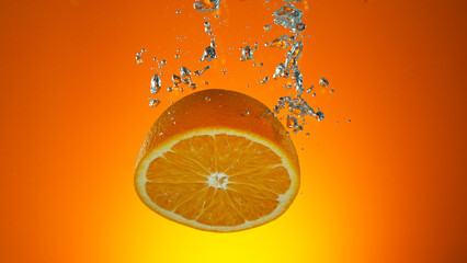Freeze motion of falling fresh orange fruit into water