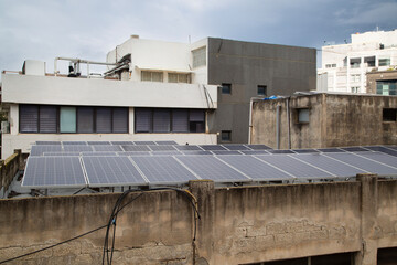 Urban solar panels on building rooftops in Ramat Gan, Israel, under overcast sky, signaling sustainable energy transition