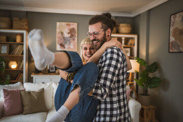 Fototapeta premium One adult couple dance together and have fun at living room at home