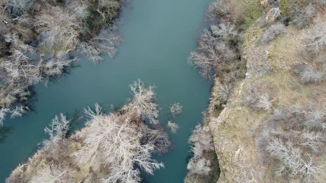 drone flying over the esla river in le&oacute;n on a winter morning with frozen trees. Video in blue and green tones