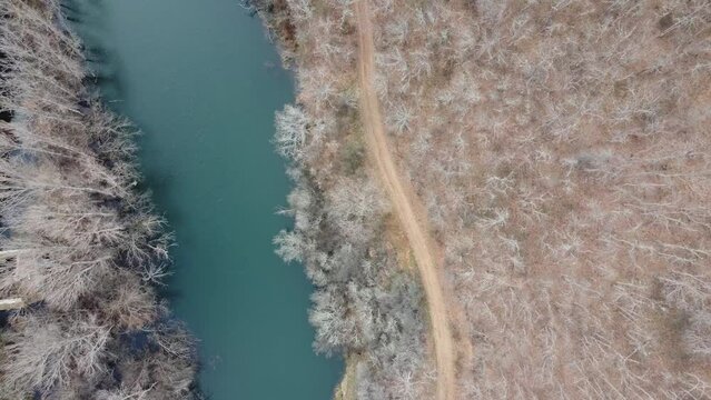 drone flying over the esla river in le&oacute;n on a winter morning with frozen trees. Video in blue and green tones