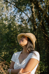 Beautiful young woman enjoying the sun. 
Young woman wearing hat who is enjoying the sun, her eyes are closed.