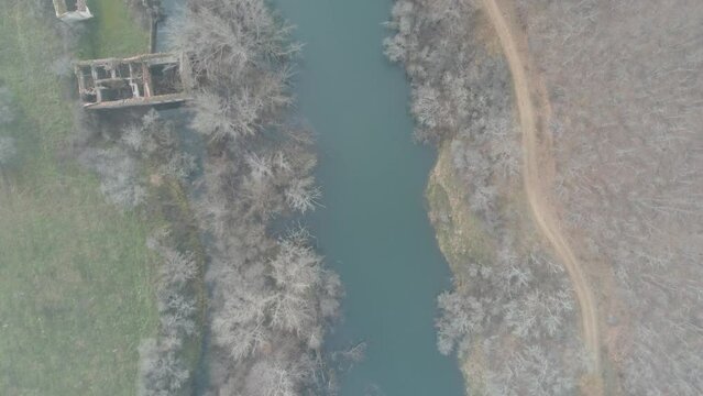 drone flying over the esla river in le&oacute;n on a winter morning with frozen trees. Video in blue and green tones