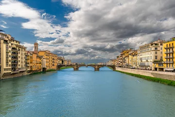 Cercles muraux Ponte Vecchio River Arno flows through the historic center of Florence, Italy, among ancient palaces with Santa Trinita arch bridge