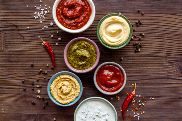 Many different sauces in bowls with spices and chili pepper. Food or cooking background