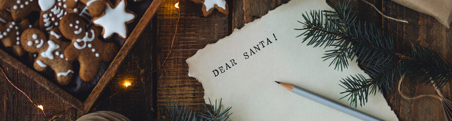 Banner. Christmas letter on craft paper to Santa Claus with text: Dear Santa. Cozy home interior...