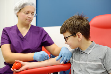 A nurse takes blood from a child using butterfly needle. Close up view during of taking a blood sample for examination in a modern laboratory or hospital. - 785738999
