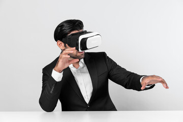 Professional businessman wearing visual reality glasses and suit while sitting. Smart caucasian...