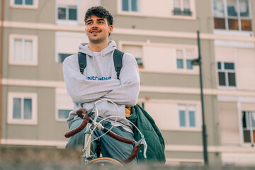 young man or student on the street riding the vintage bicycle
