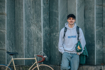 young man on street wall with vintage bicycle and copy-space