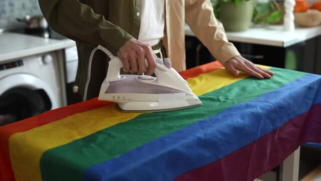 detail of man ironing the gay pride flag