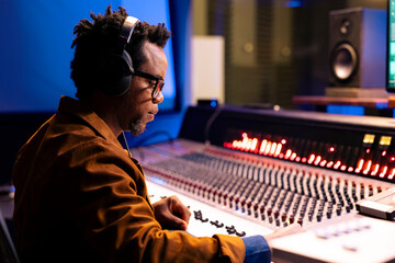 African american audio expert editing tracks in professional recording studio, mixing and mastering...