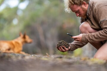 regenerative organic farmer, taking soil samples and looking at plant growth in a farm. practicing sustainable agriculture.