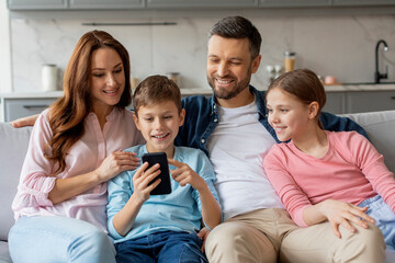 Happy family using smartphone together, home interior