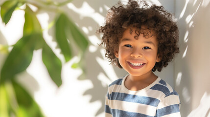 A cute smilling african 4-5 year old kid against a white wall. A boy is wearing denim jeans and a striped T-shir. Generative AI