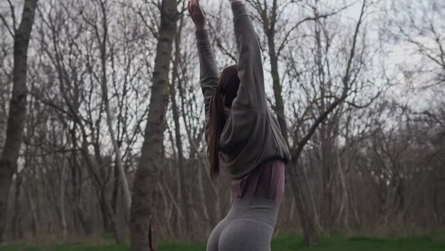 Girl in sportswear doing yoga outdoors 