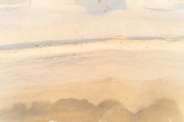 sand on the shore of a beach at sunrise at low tide aerial top view with drone